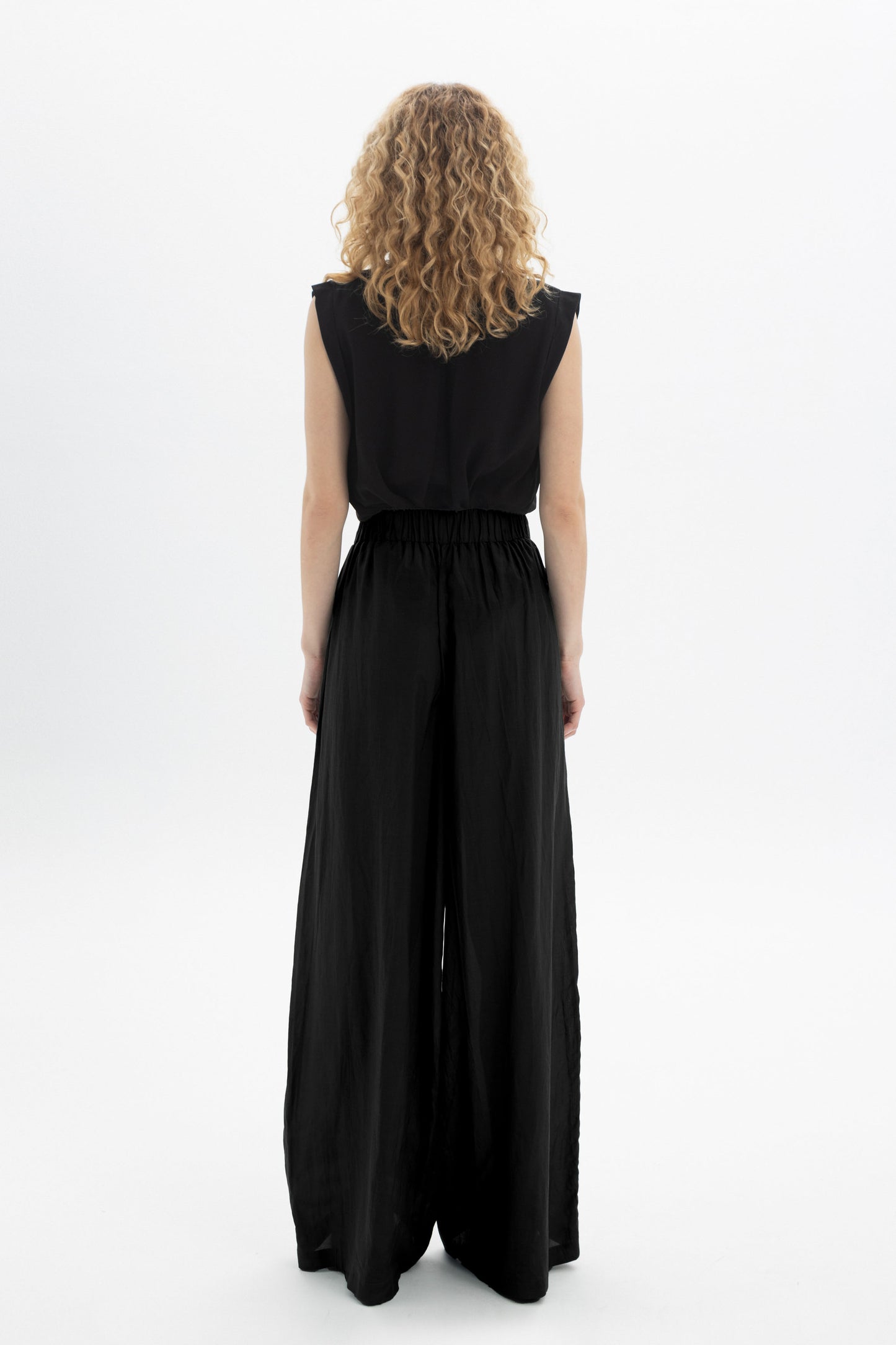 Black and Black wide-leg belted pants with a high waist and relaxed fit, shown on a model.