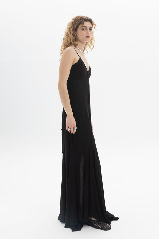A model wearing a V-Neck Maxi Dress featuring a flowing tiered hem and thin straps, perfect for a relaxed fit.