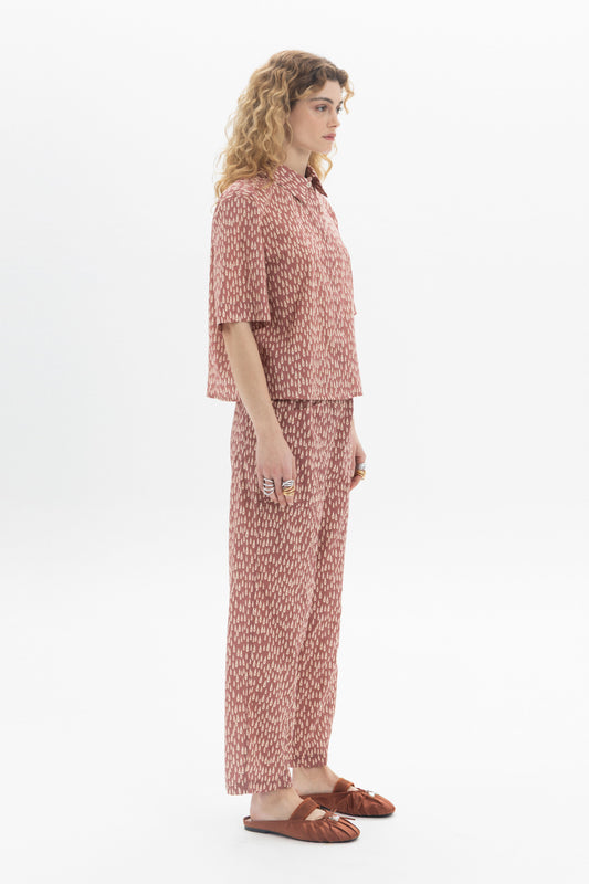 Model wearing a Short Sleeve Shirt with abstract print, styled with matching pants for a modern look.