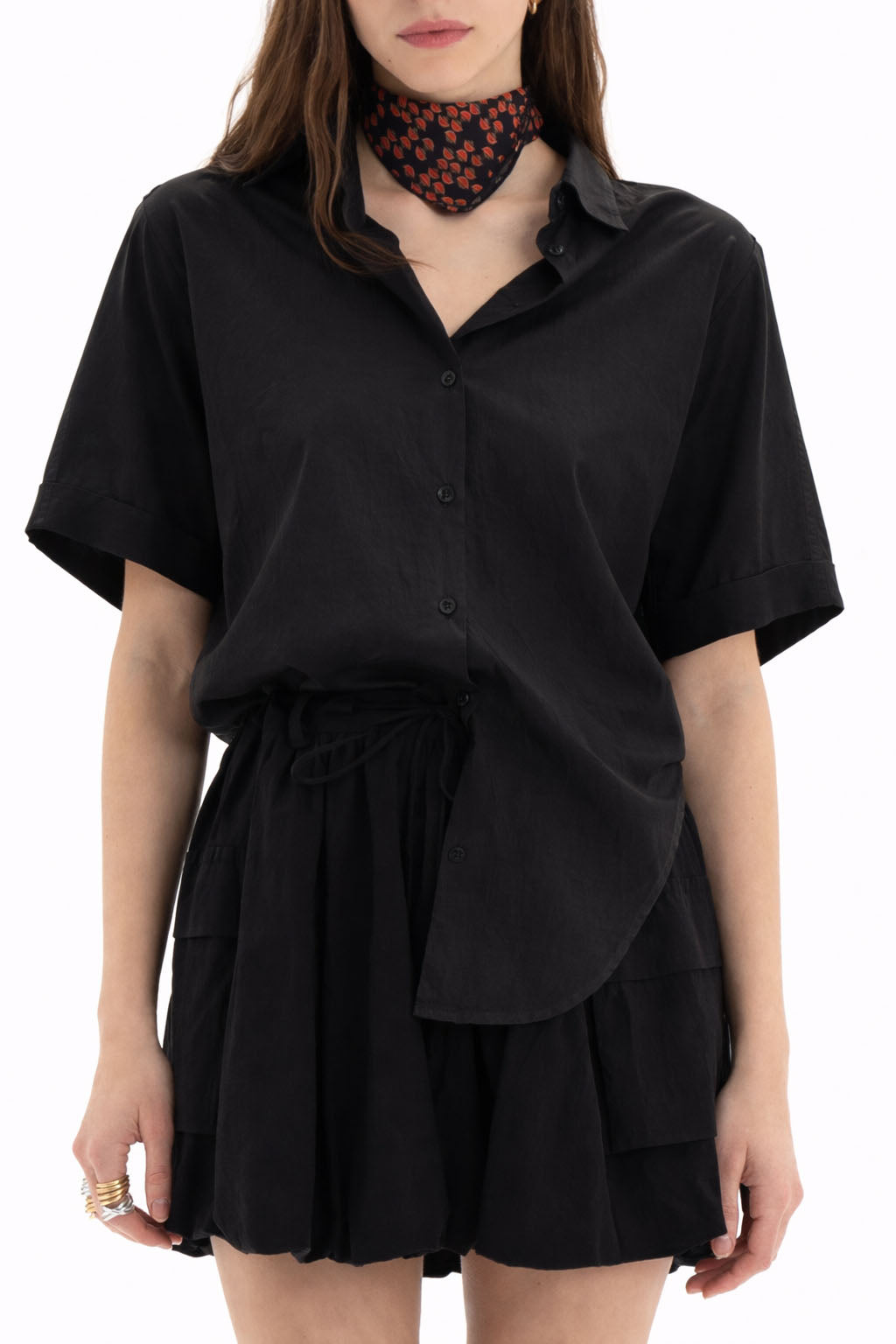 Cotton Short Sleeve Shirt featuring a relaxed fit, classic collar, and dropped shoulders, styled with a black skirt.