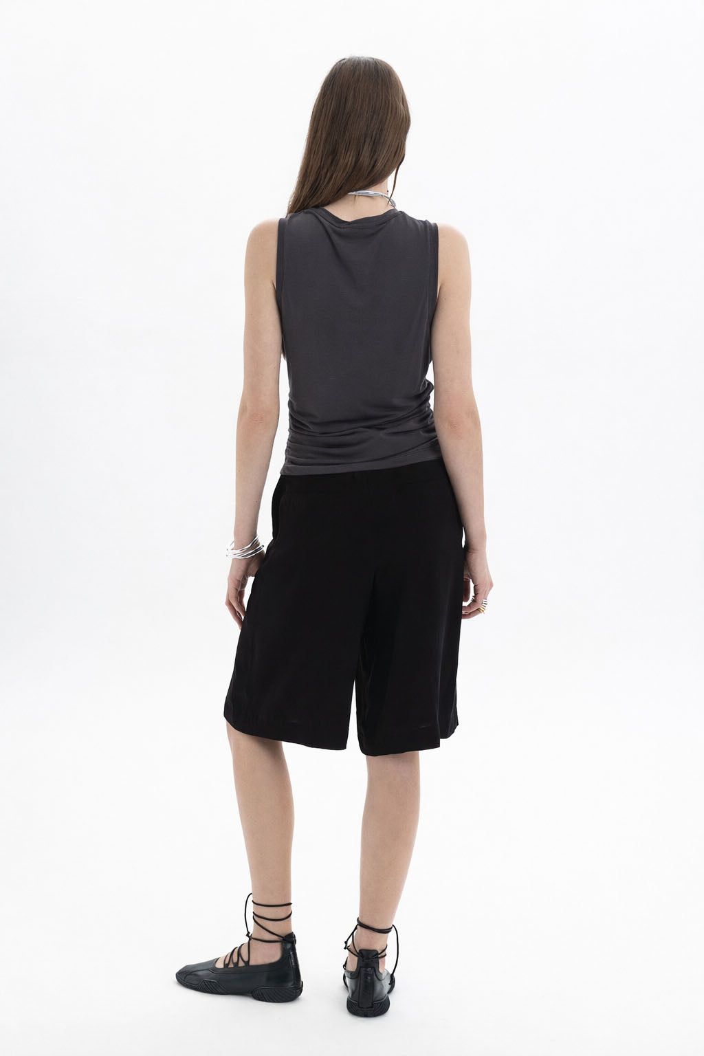 Ruched Sleeveless Top worn by a model, showcasing the back view with side ruching and a contemporary silhouette.