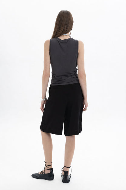 Ruched Sleeveless Top worn by a model, showcasing the back view with side ruching and a contemporary silhouette.