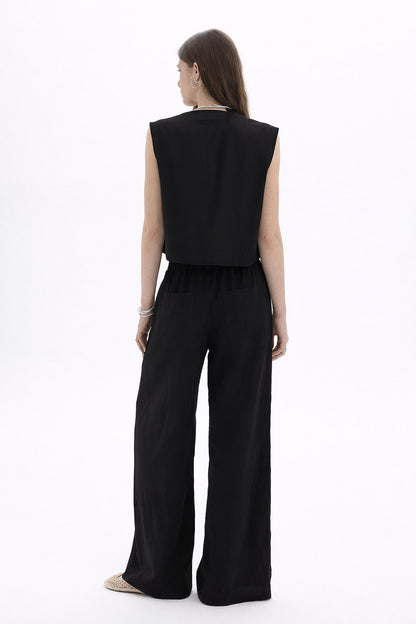 Back view of a model wearing a Pleated Cropped Sleeveless Top paired with wide-leg trousers.