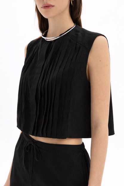 Model wearing a Pleated Cropped Sleeveless Top with soft front pleats and round neckline.