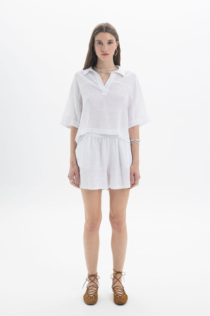 Model wearing a Linen Polo Top, a lightweight cropped linen top with a soft collar and relaxed fit.
