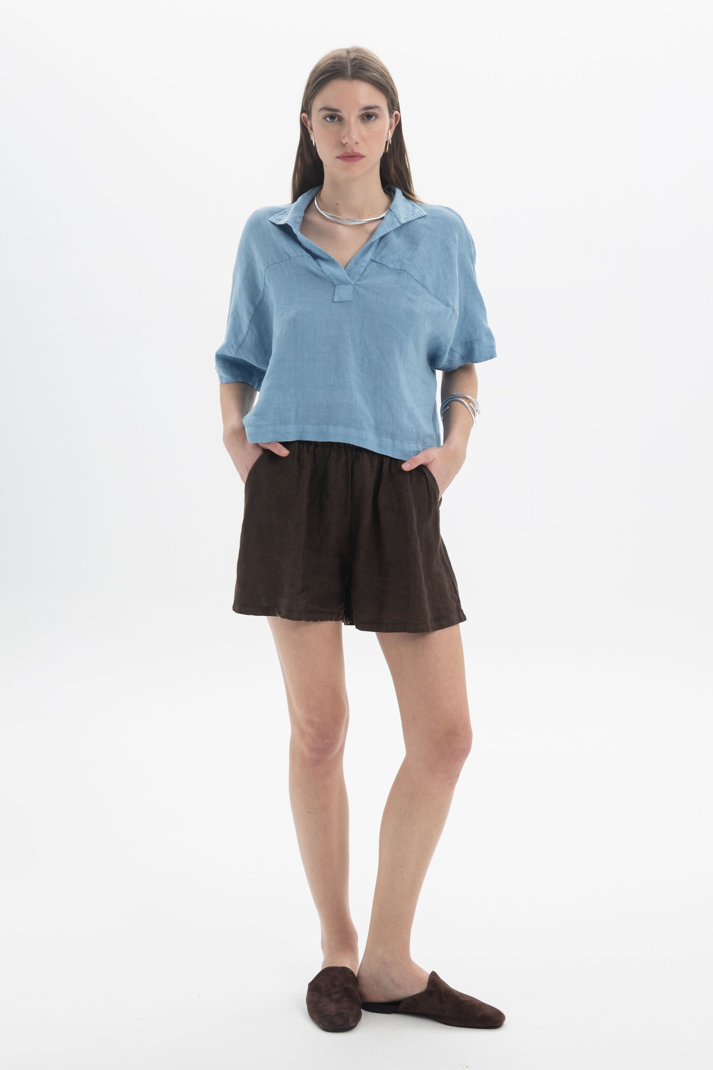Woman wearing Linen Shorts paired with a blue linen top, showcasing a relaxed summer look.