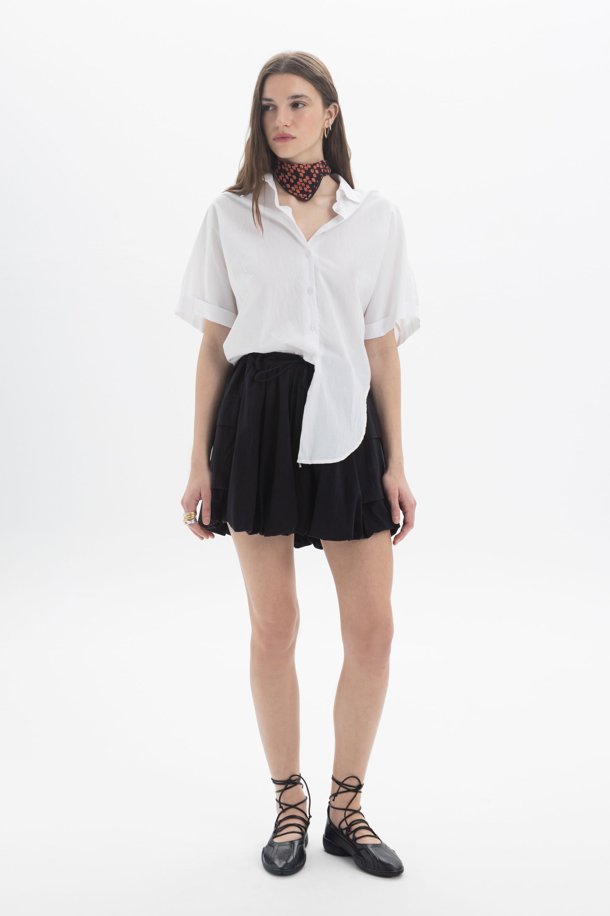 Model wearing a Cotton Short Sleeve Shirt paired with a black skirt and stylish accessories.