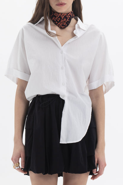 Cotton Short Sleeve Shirt worn by a model with a black skirt and scarf, showcasing a relaxed-fit and modern silhouette.