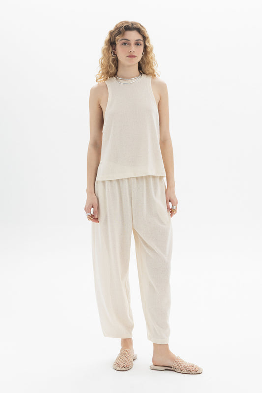 Model wearing a sleeveless textured top and lightweight pants, showcasing a relaxed silhouette in a breathable design.