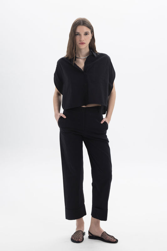 Cropped Button Shirt styled with relaxed black pants, showcasing a modern summer outfit with minimal silhouette.