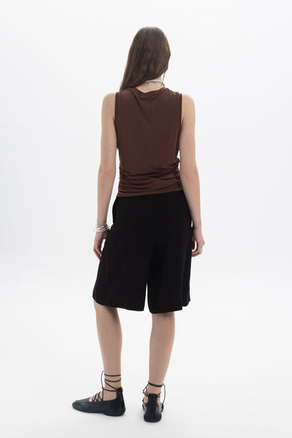 Back view of a model wearing Tailored Bermuda Shorts with a relaxed fit and mid-rise waist.