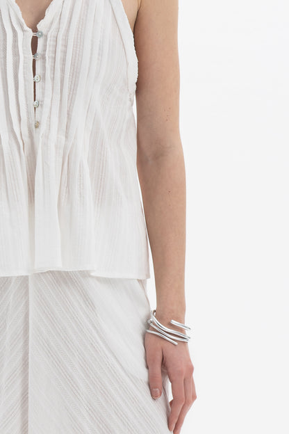 Pleated Halter Peplum Top featuring delicate pleats, buttoned front, and airy peplum silhouette.
