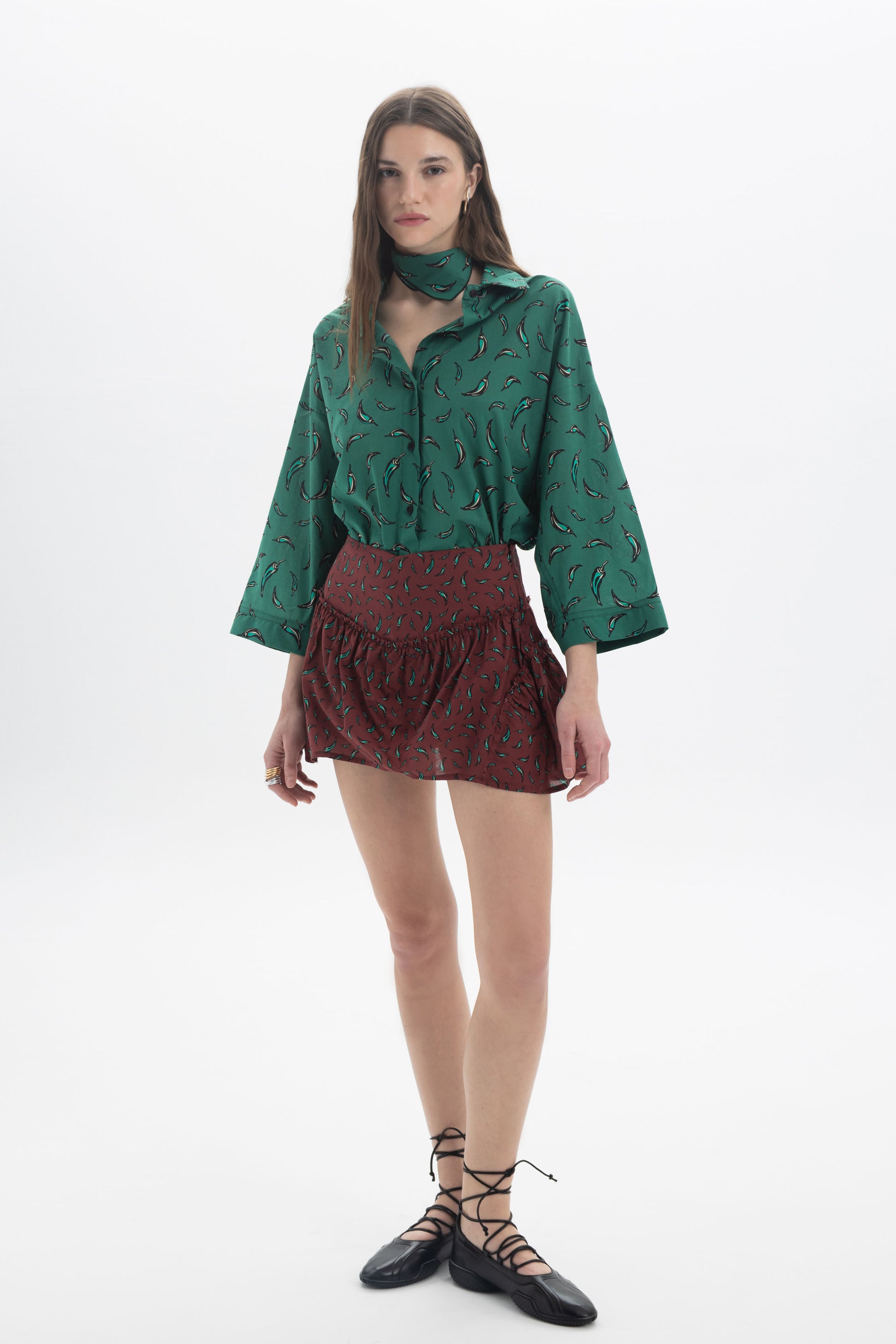 Model wearing a Mini Skort paired with a green patterned blouse and black lace-up flats.