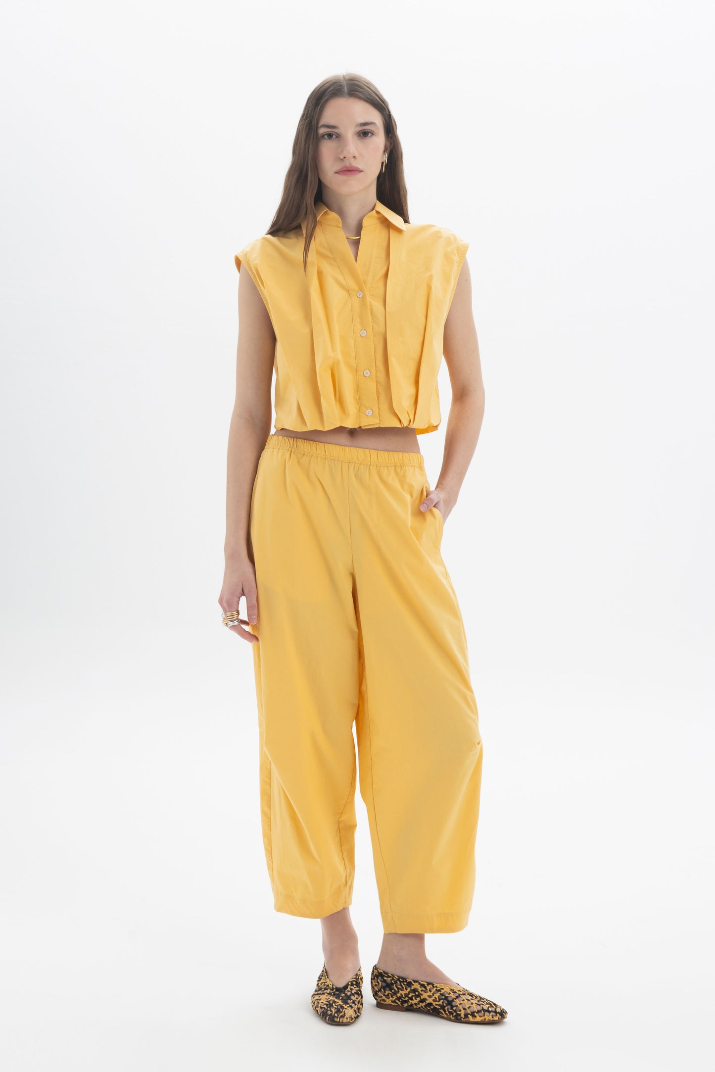 Cropped Sleeveless Shirt styled with yellow wide-leg pants, showcasing a modern and effortless outfit.