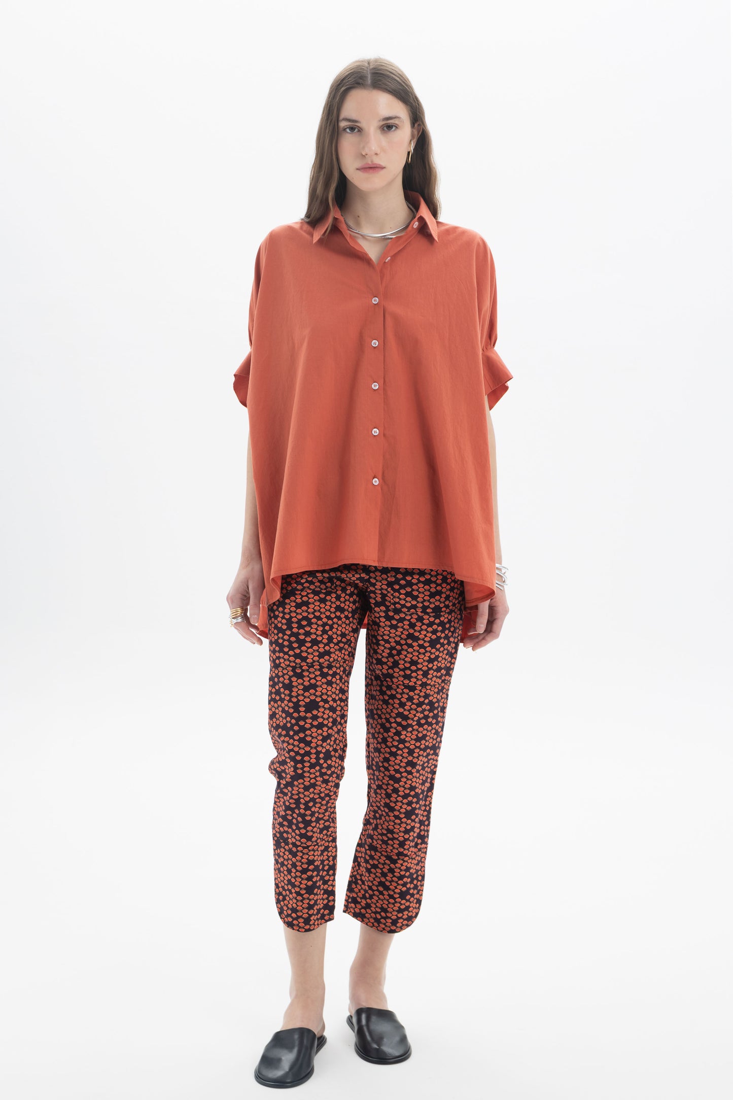 Model wearing Cropped Printed Pants with an orange oversized shirt, showcasing a stylish everyday look.