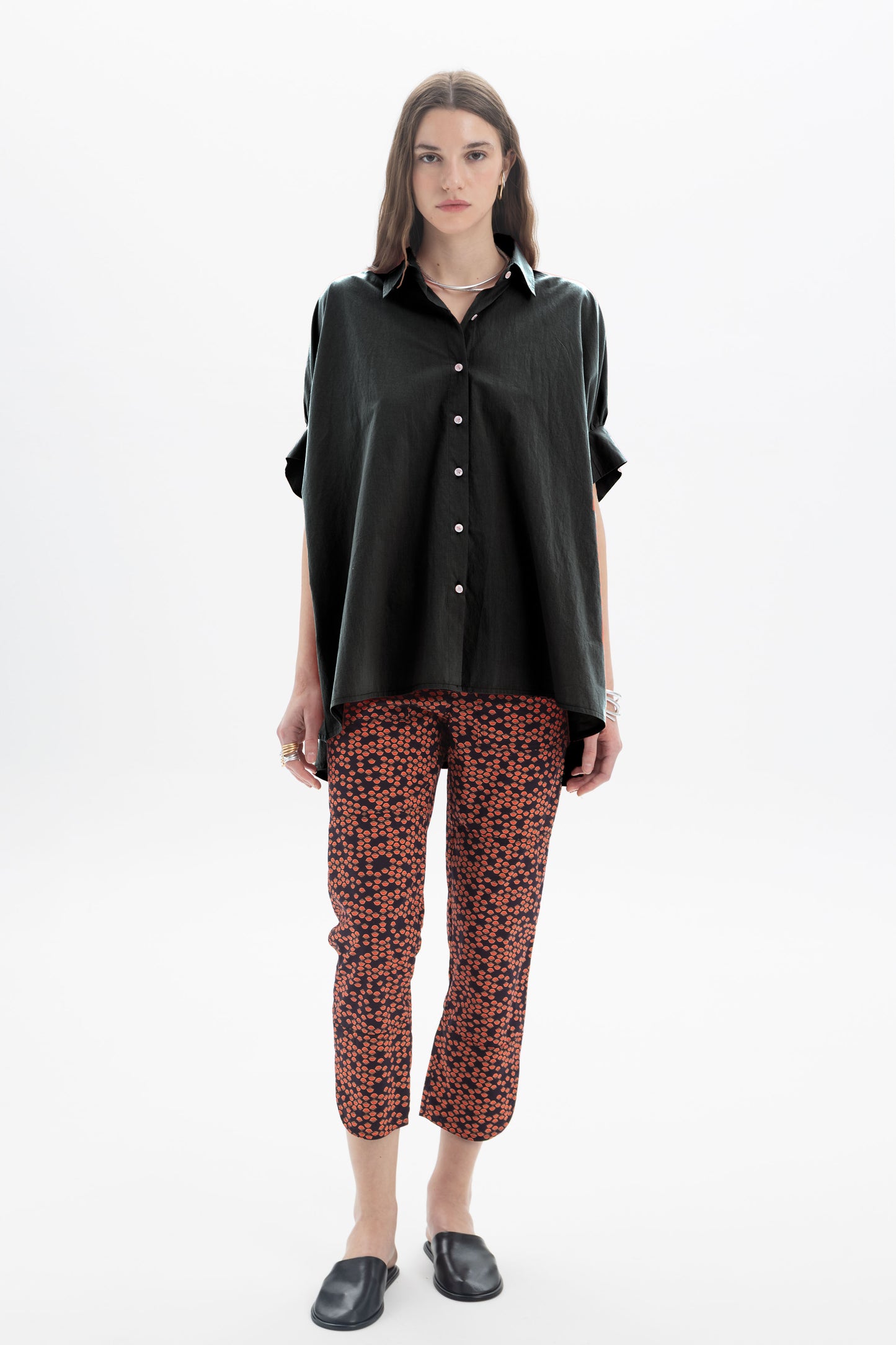 Black and Black oversized short sleeve button-up shirt displayed on a hanger, featuring a relaxed fit and classic collar.
