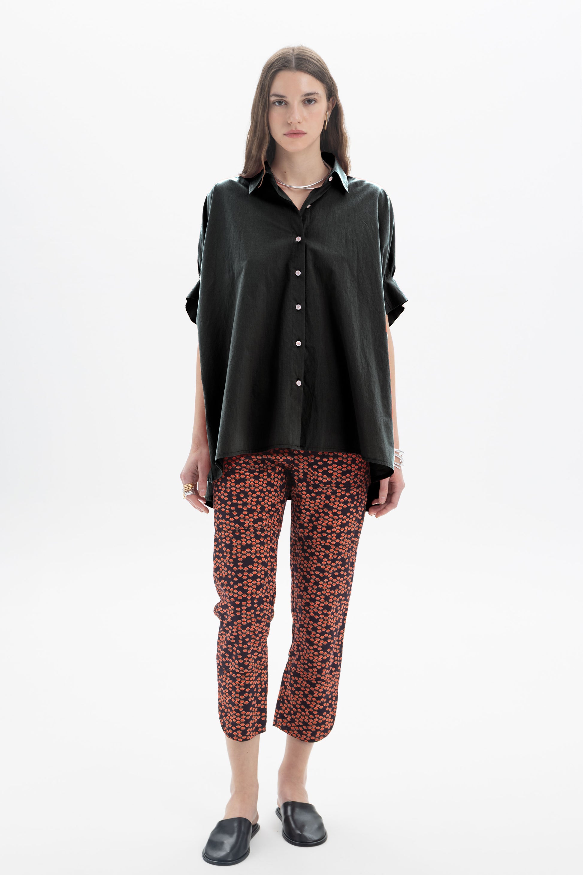 Black and Black oversized short sleeve button-up shirt displayed on a hanger, featuring a relaxed fit and classic collar.