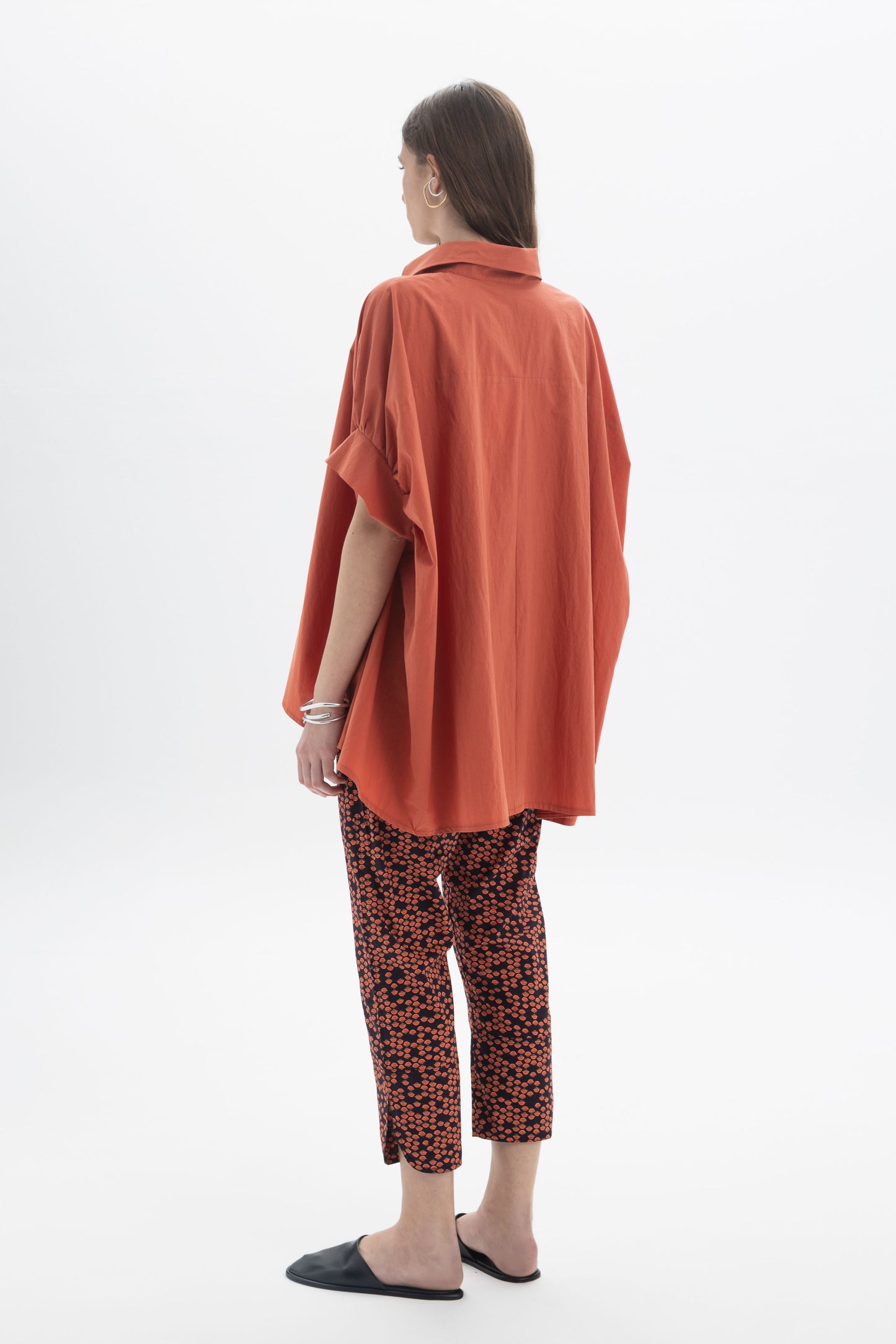 Model wearing Cropped Printed Pants with an oversized orange shirt, showcasing a stylish casual look.