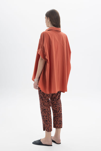 Model wearing Cropped Printed Pants with an oversized orange shirt, showcasing a stylish casual look.
