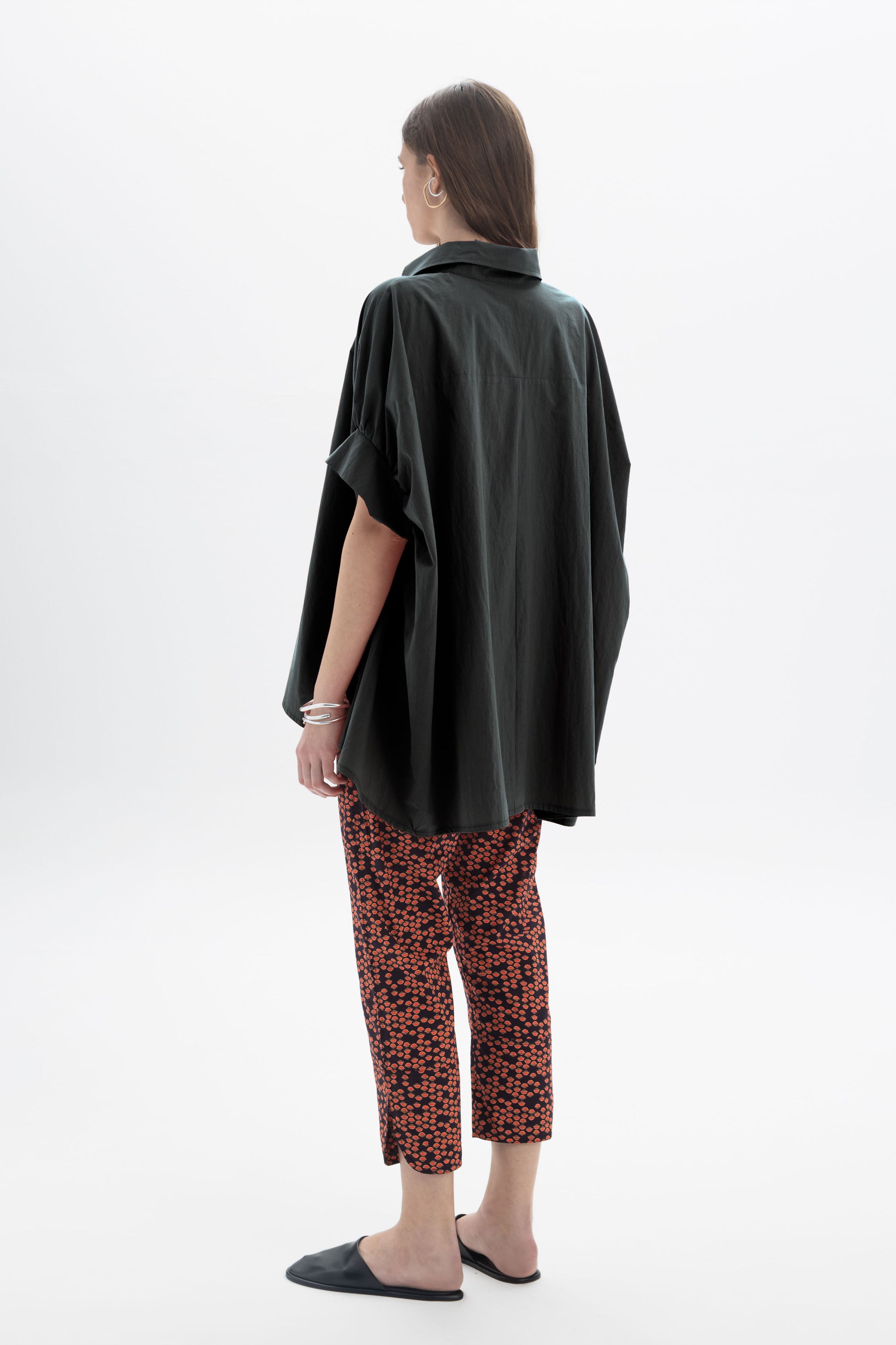 Black and Black oversized short sleeve button-up shirt, relaxed fit with a classic collar and front buttons, displayed on a hanger.
