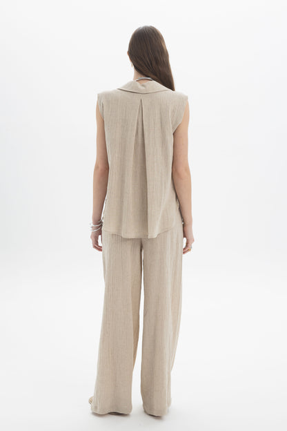 Back view of a model wearing a Sleeveless Textured Collar Blouse paired with wide-leg pants.