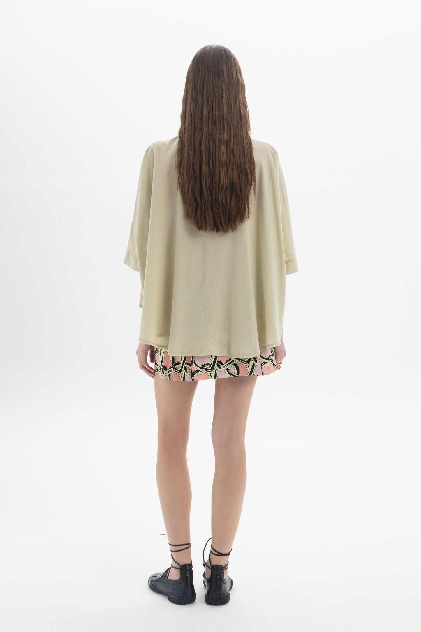 Woman wearing an Elbow Length Shirt with wide sleeves, viewed from the back, showcasing a relaxed and modern look.