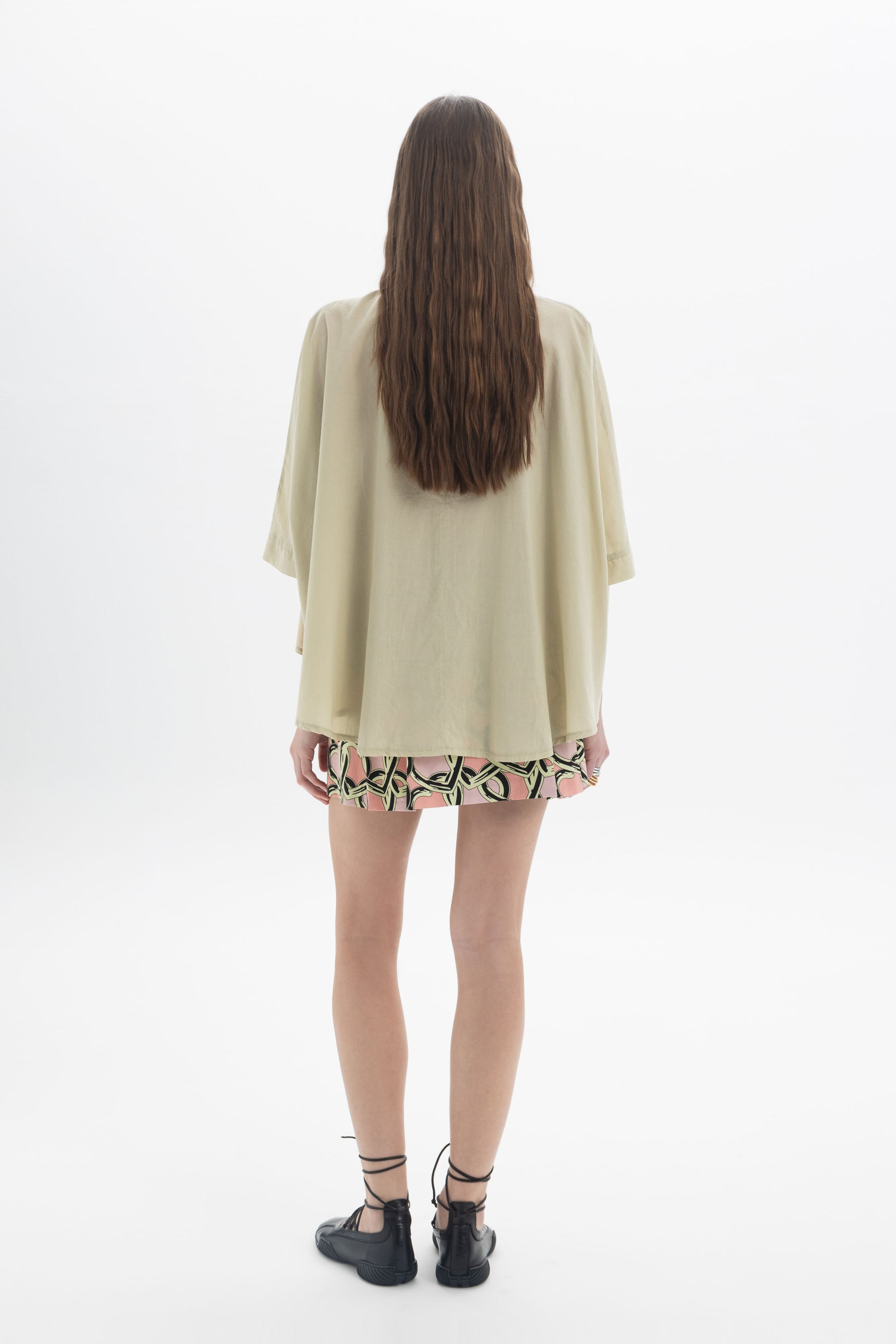 Woman wearing an Elbow Length Shirt with wide sleeves, viewed from the back, showcasing a relaxed and modern look.