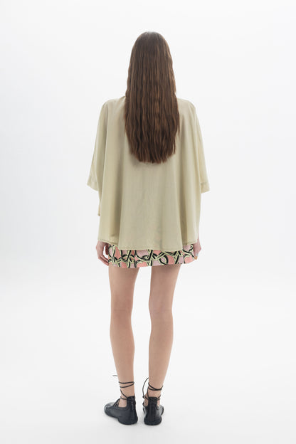 Woman wearing an Elbow Length Shirt with wide sleeves, viewed from the back, showcasing a relaxed and modern look.