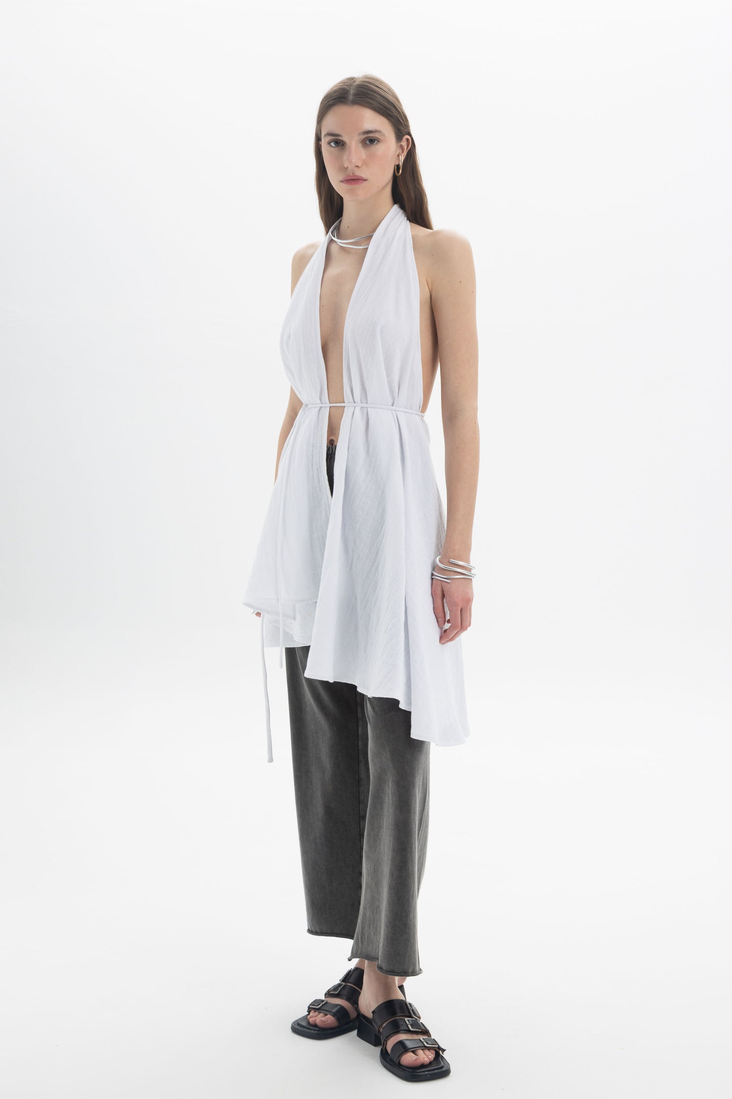 Model wearing a Longline Halter Top with a deep neckline and adjustable waist tie, paired with trousers.