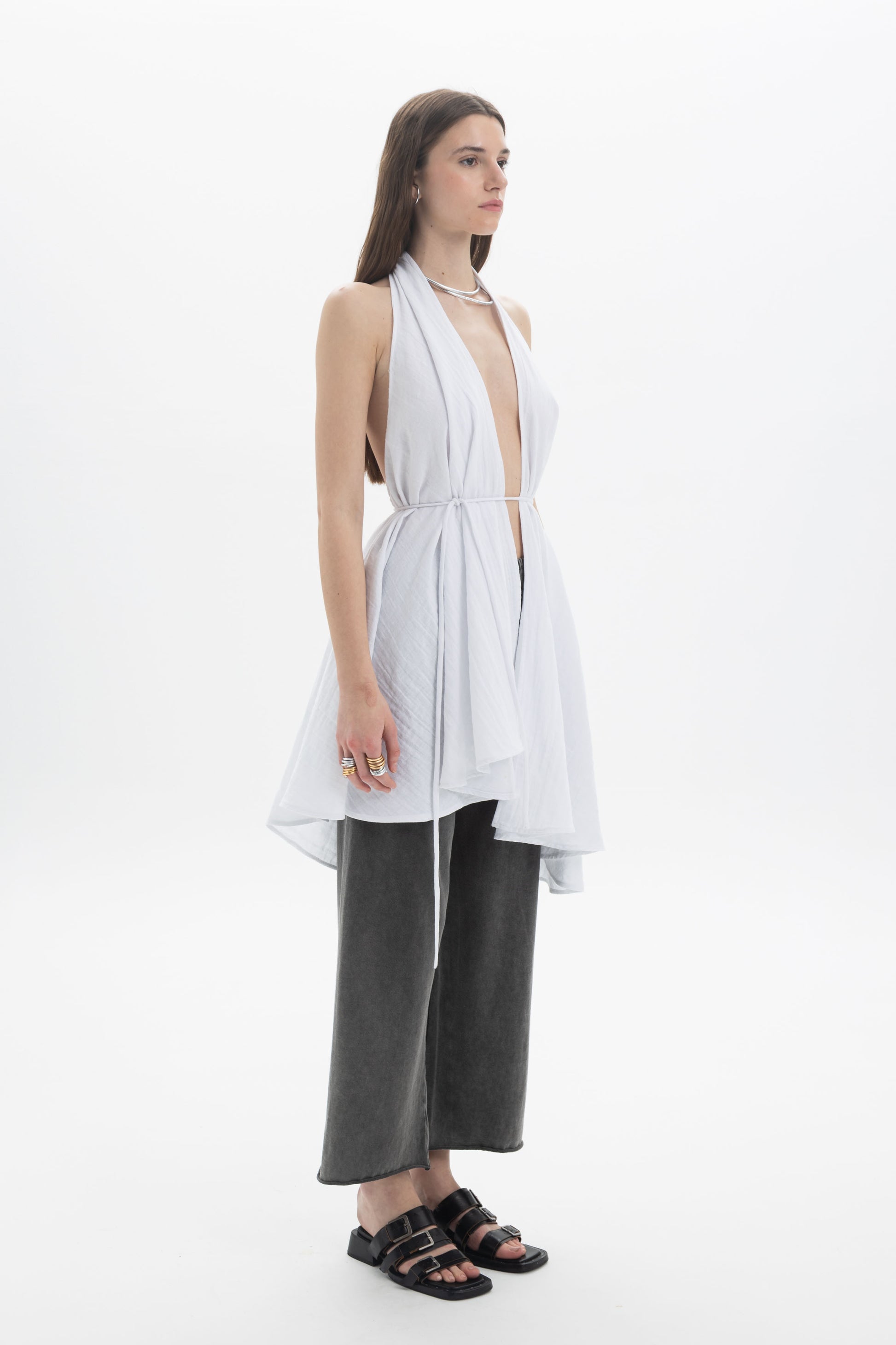 Longline Halter Top in white with a deep neckline and draped panels, styled with loose pants.