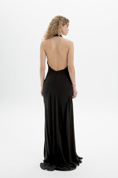 Back view of a model wearing a Halter Wrap Maxi Dress showcasing the deep neckline and open back design.