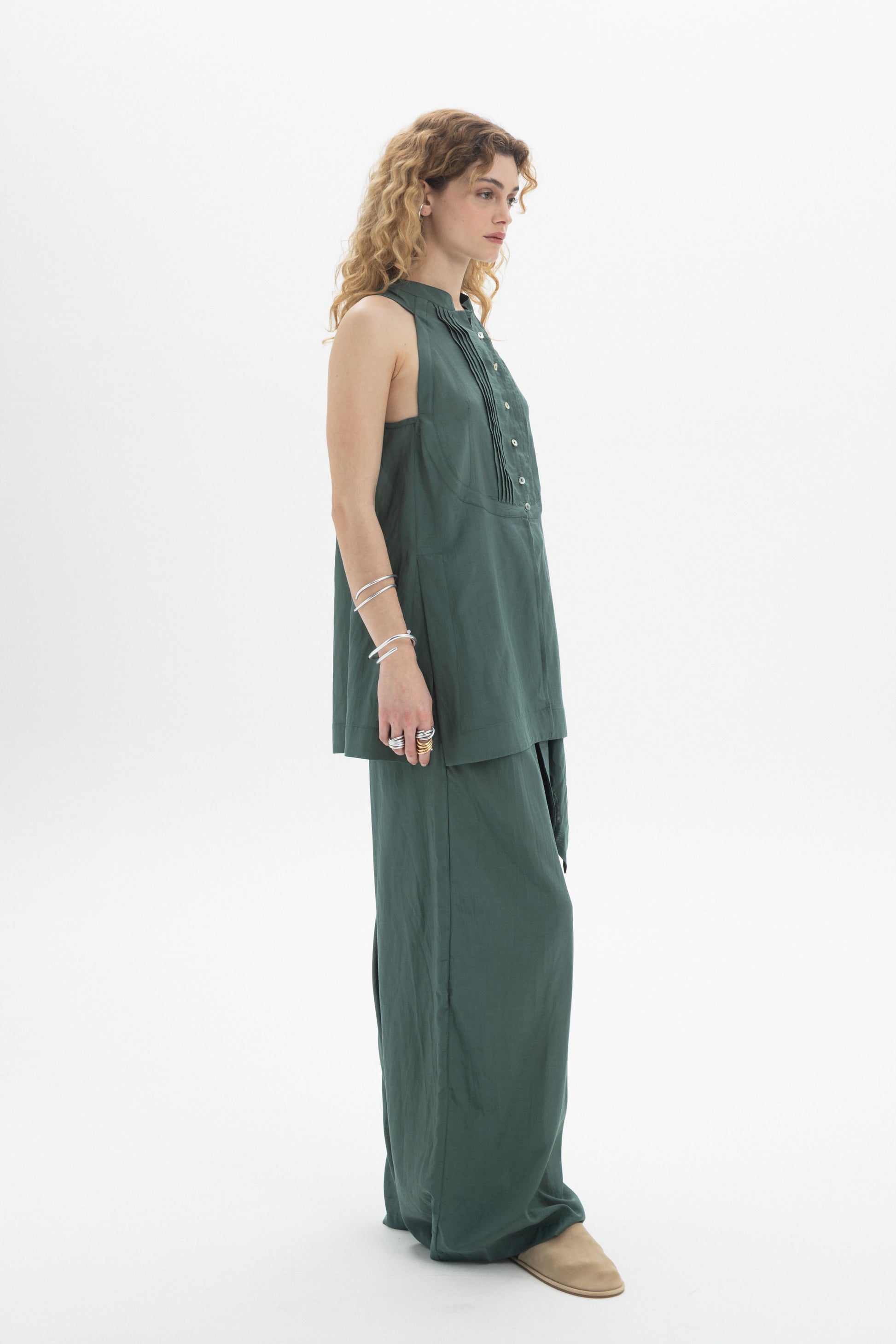 Sleeveless Bib Shirt in green cotton with bib front, button closure, and relaxed A-line silhouette.