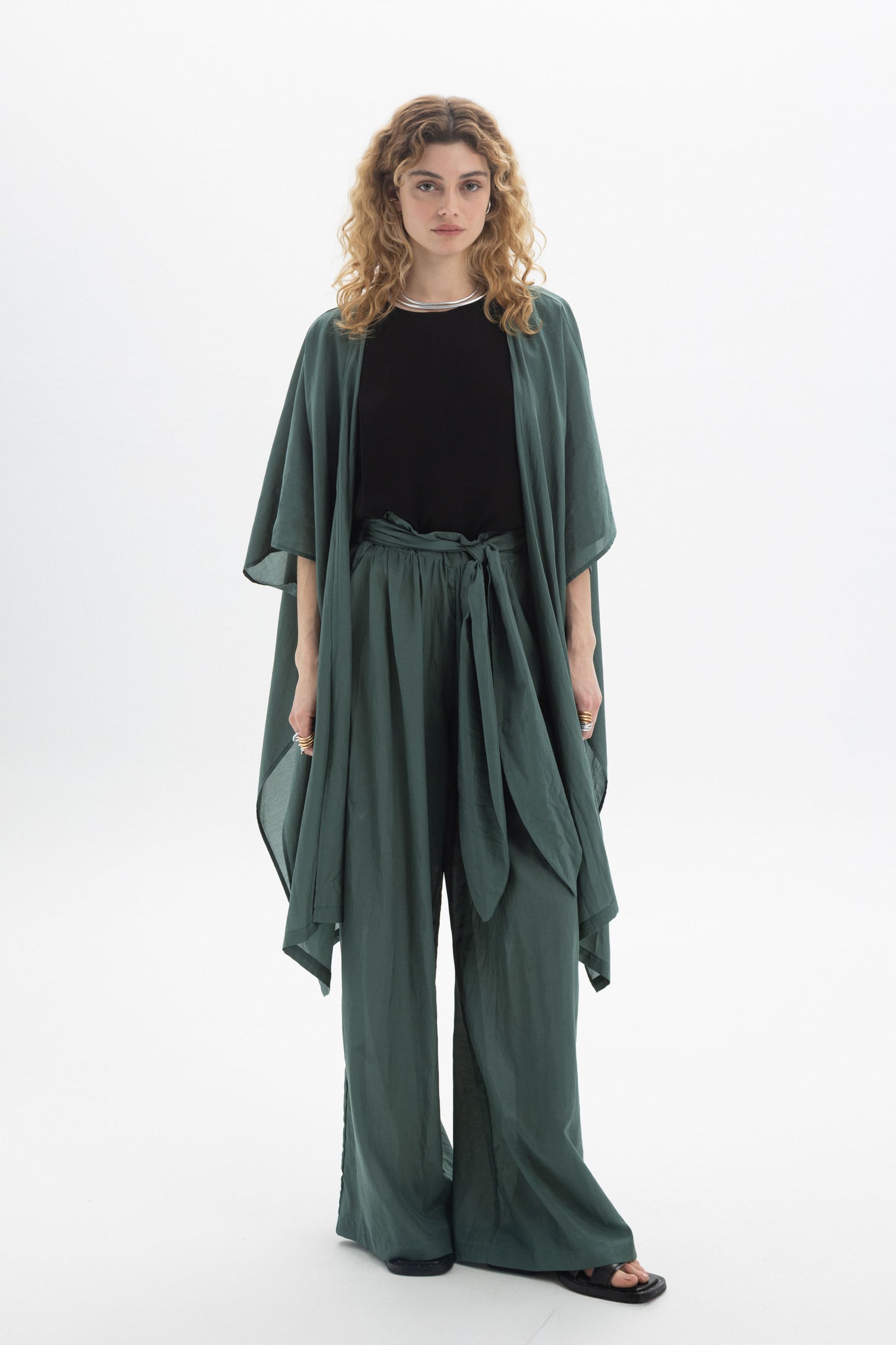 Model wearing a Sheer Kimono over a black top and matching green pants, showcasing its relaxed and airy design.