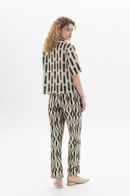 Model wearing Abstract Straight Trousers with an abstract print, showcasing the stylish cropped design and elastic waistband.