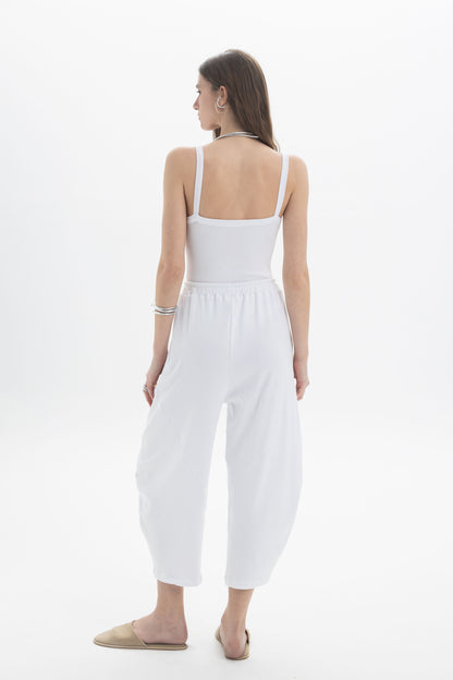 Back view of a model wearing the B&B x F Ribbed Strap Body, showcasing a fitted design and relaxed trousers.
