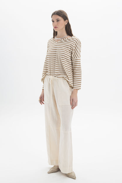 Model wearing B&B x F Striped Relaxed Top with dropped shoulders and relaxed fit, styled with light trousers.
