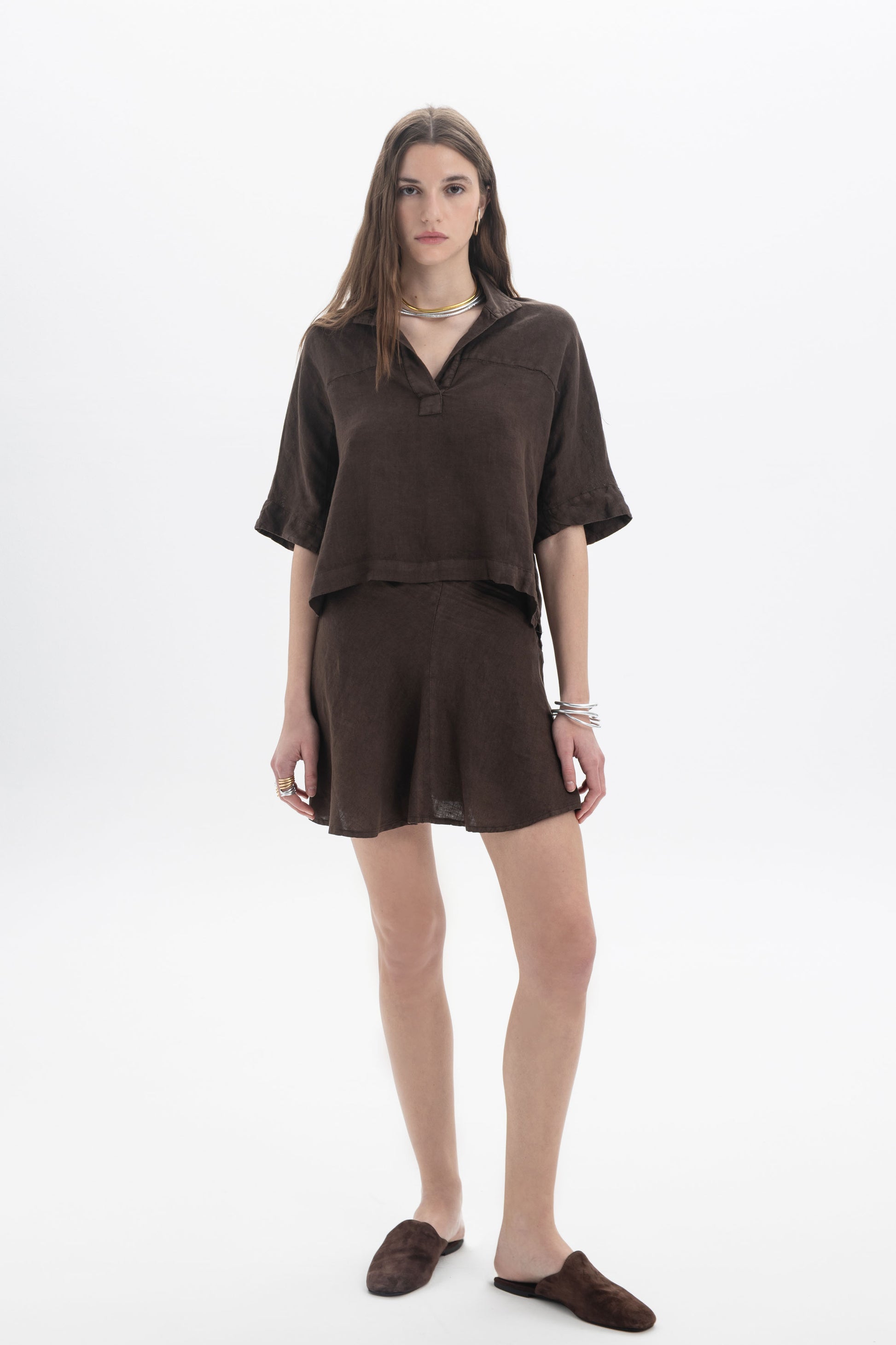 Model wearing a Linen Polo Top in dark brown, featuring a short-sleeve design and relaxed silhouette.