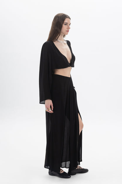 Model showcasing a Draped Cropped Long Sleeve Top with a deep V neckline and flowing silhouette.
