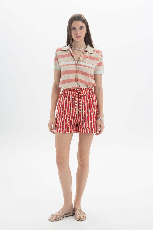 Model wearing a Striped Knit Polo with a relaxed fit and striped design paired with colorful shorts.