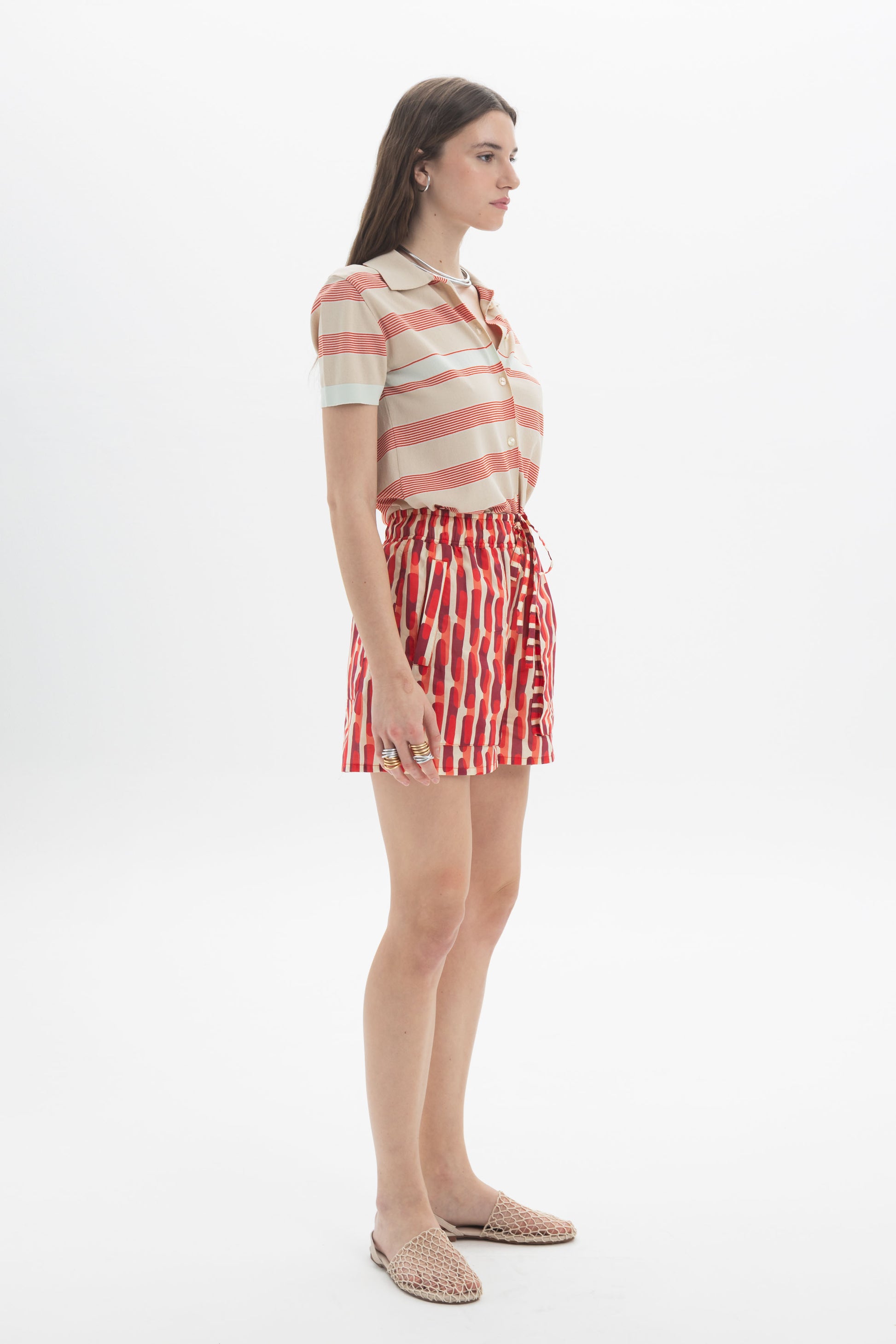 Model wearing a Striped Knit Polo with shorts, showcasing a relaxed fit and horizontal stripes for a casual look.