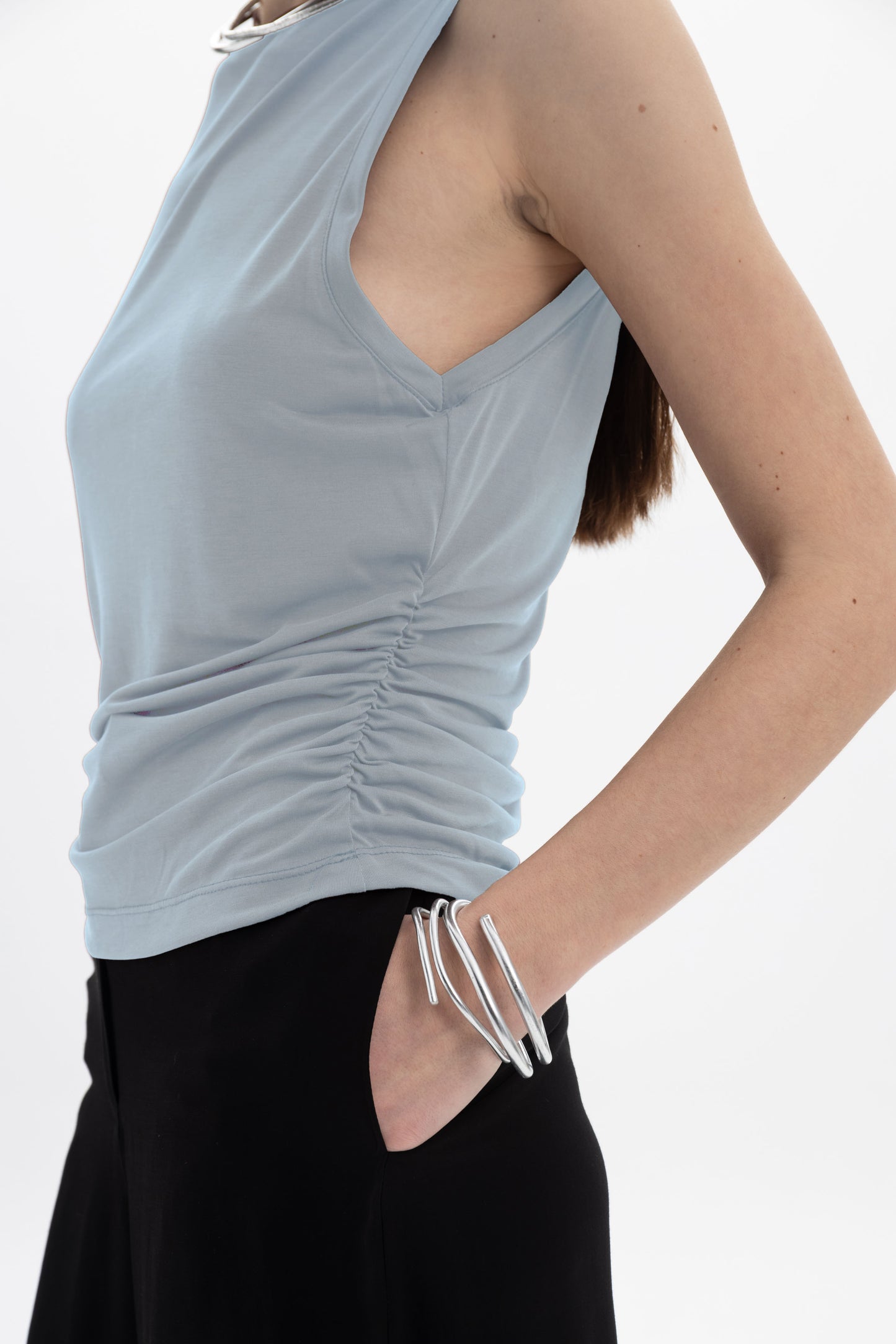 Black and Black ruched sleeveless top, close-up showing fabric texture and stylish design.