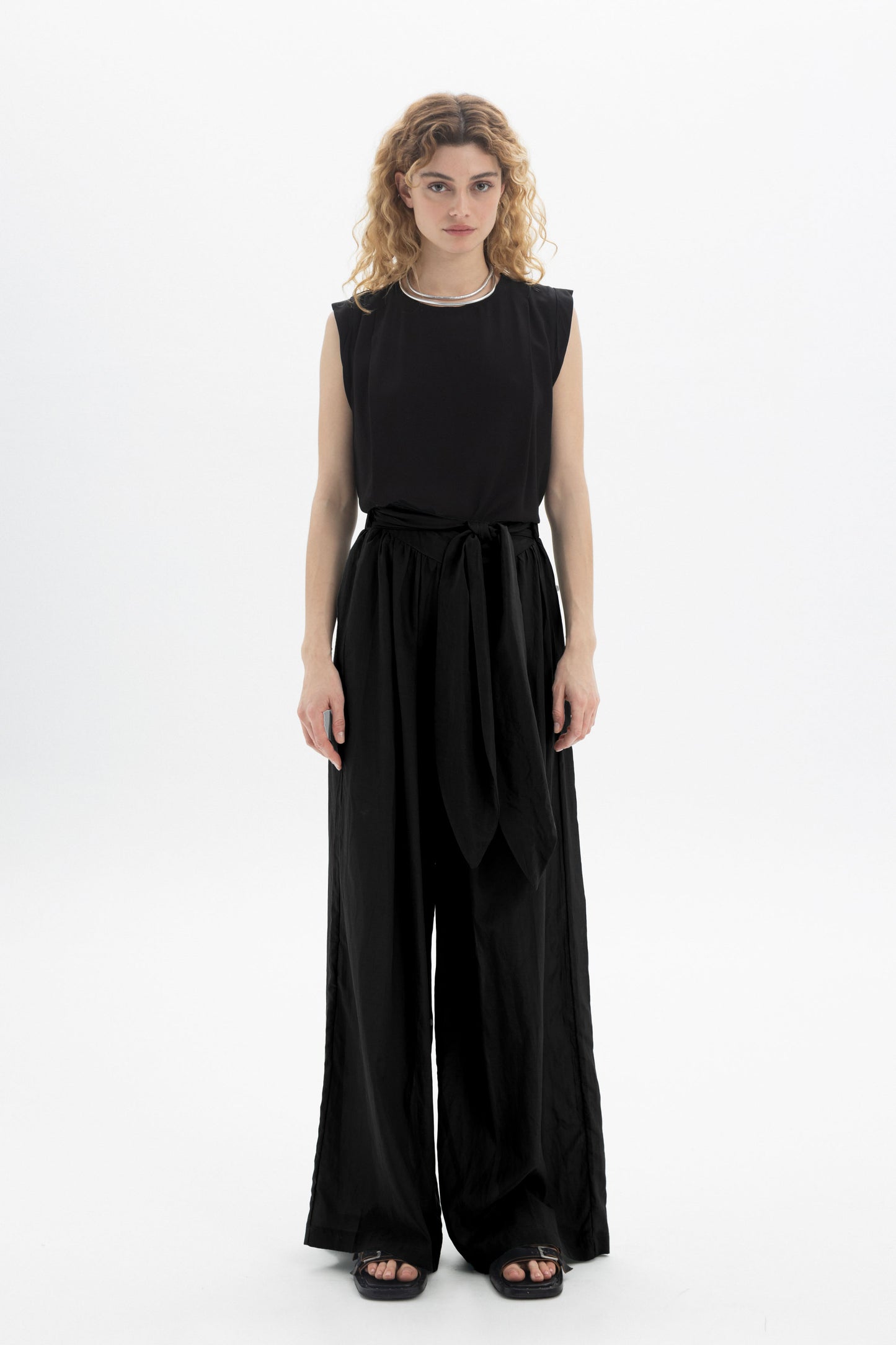 Black and Black wide-leg belted pants with a relaxed fit and high waist, shown on a model against a neutral background.