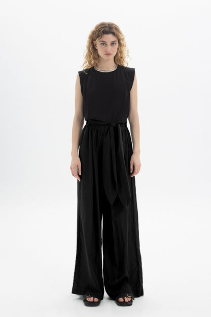 Black and Black wide-leg belted pants with a relaxed fit and high waist, shown on a model against a neutral background.