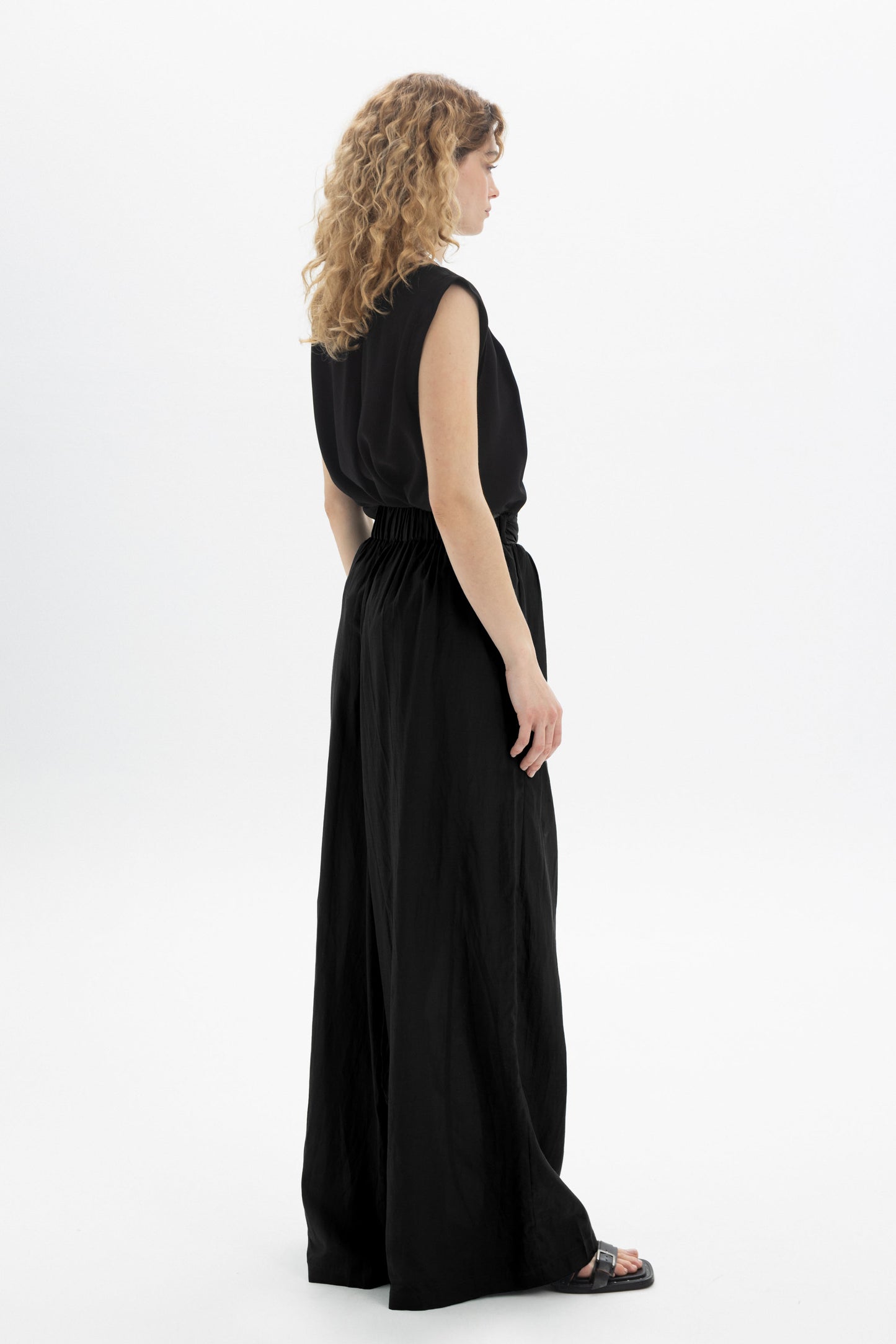 Black and Black wide-leg belted pants with a high waist and relaxed fit, shown on a model against a neutral background.