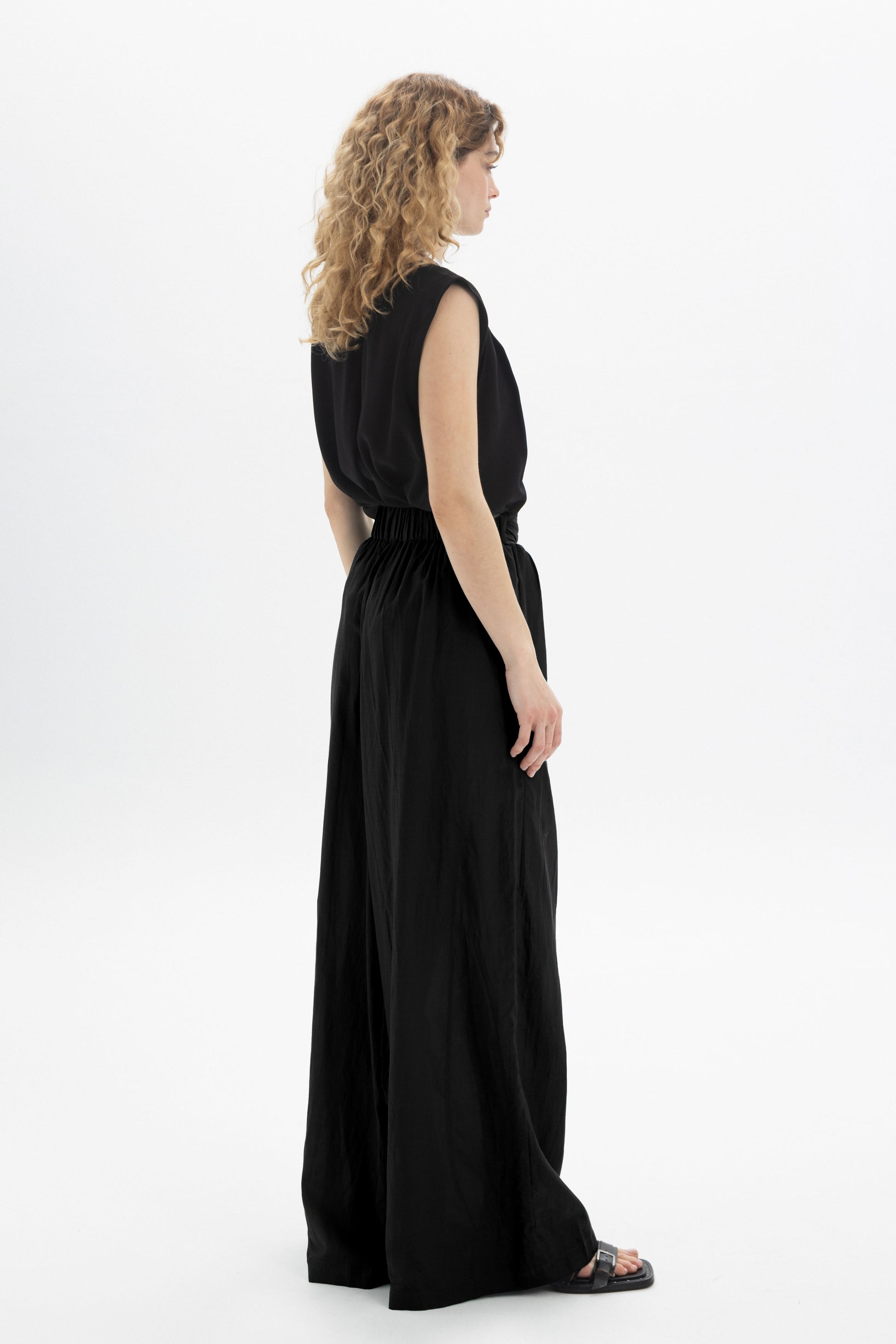 Black and Black wide-leg belted pants with a high waist and relaxed fit, shown on a model against a neutral background.