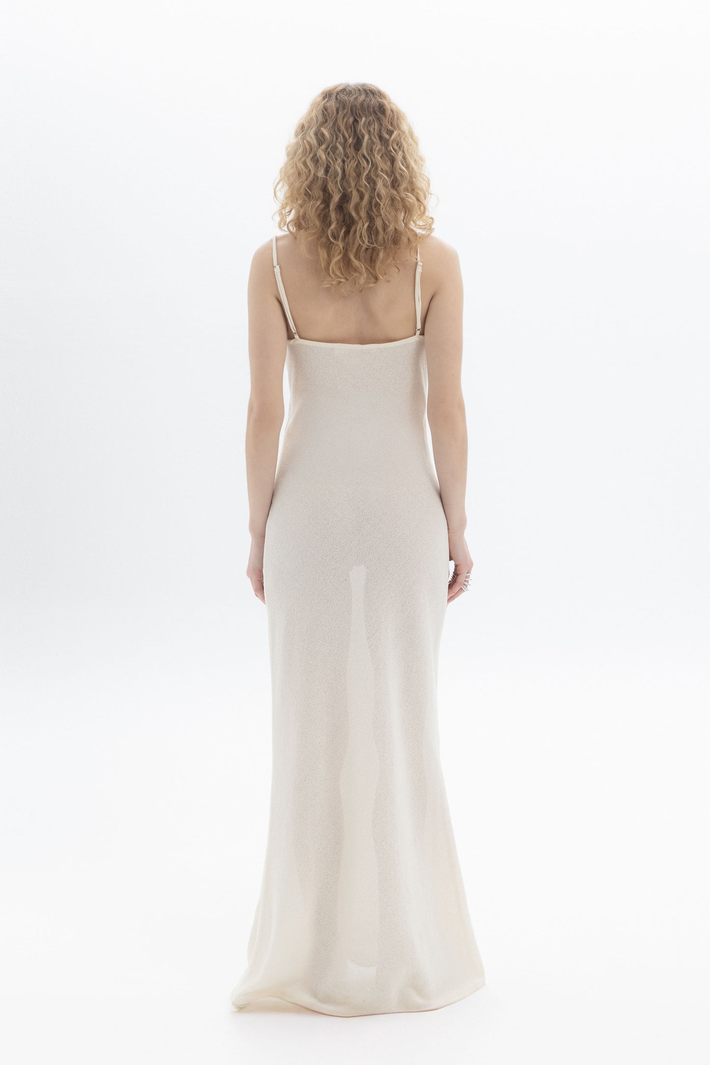 Back view of a woman wearing a Slip Maxi Dress with spaghetti straps and a slim straight fit.
