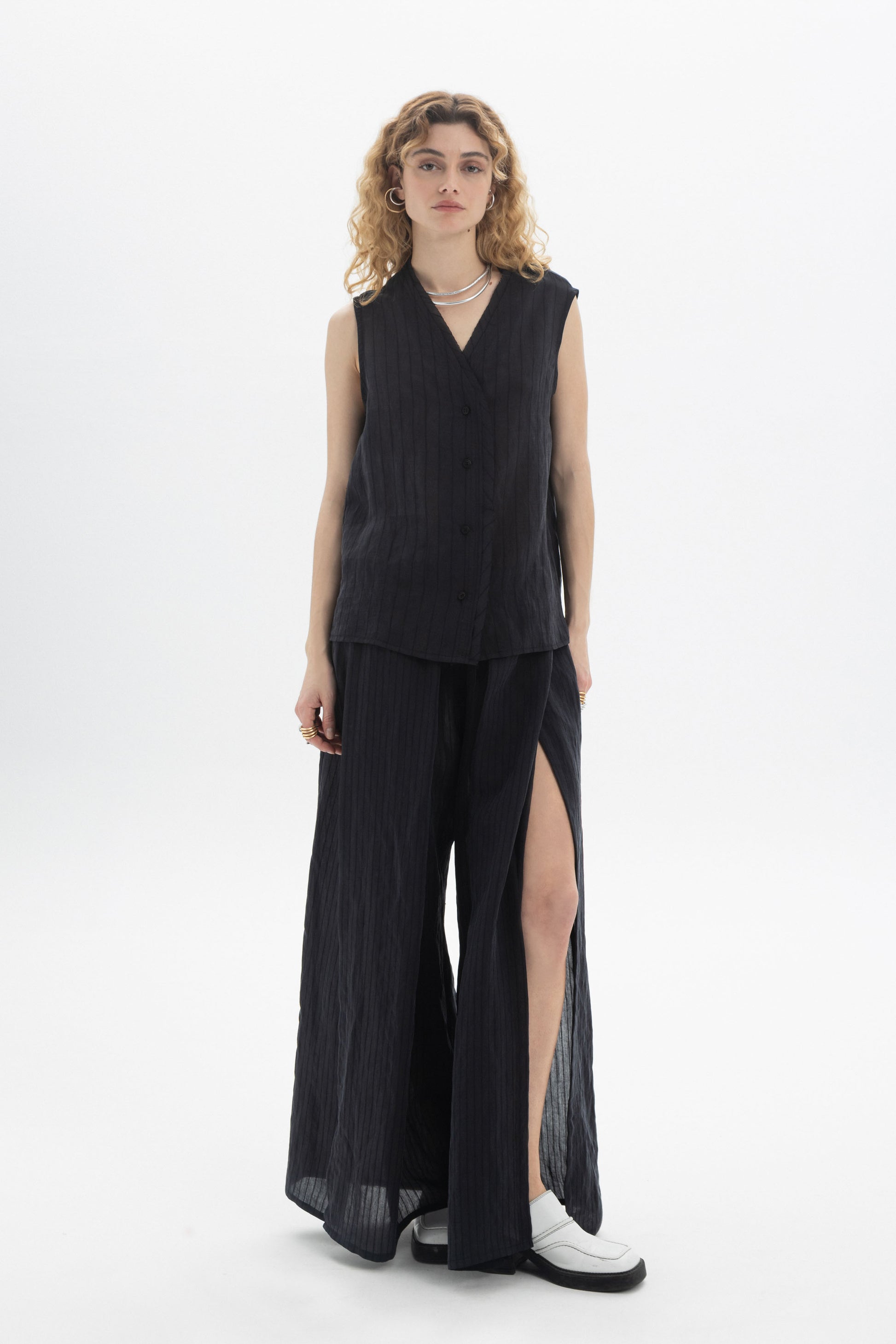Flowing Wide-Leg Slit Pants with dramatic side slits, styled in a contemporary outfit for elegance and comfort.