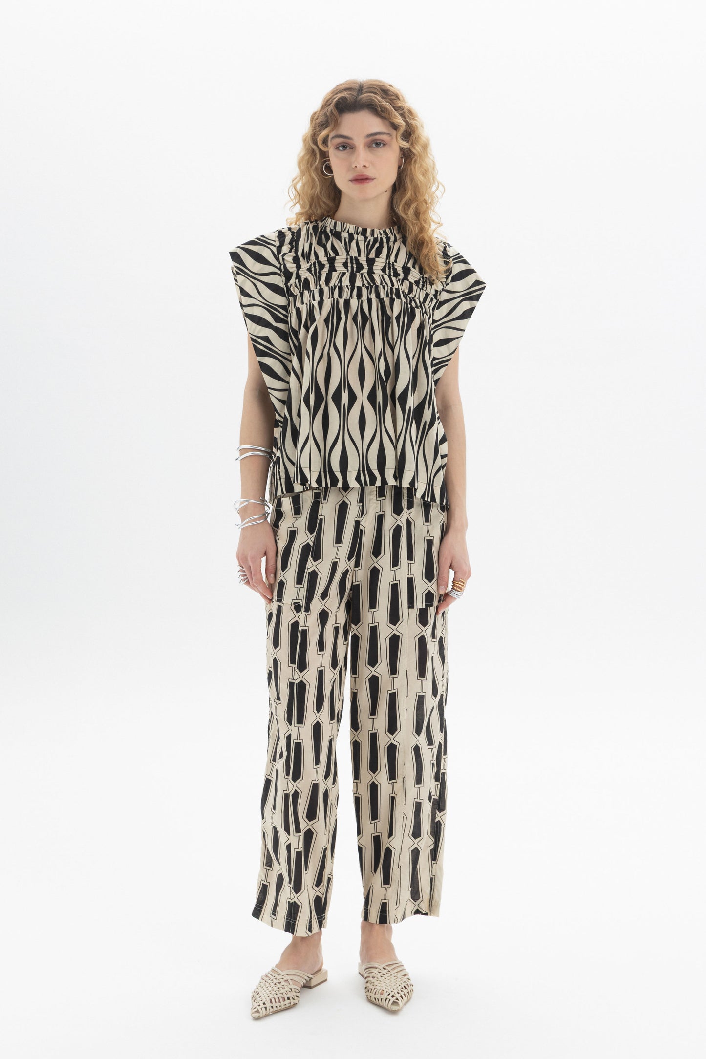 Gathered Sleeveless Top worn with patterned pants, showcasing relaxed fit and contemporary style in a stylish outfit.