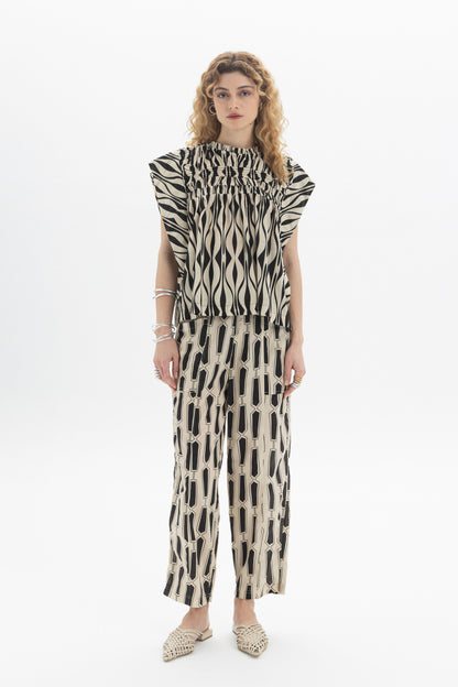 Gathered Sleeveless Top worn with patterned pants, showcasing relaxed fit and contemporary style in a stylish outfit.