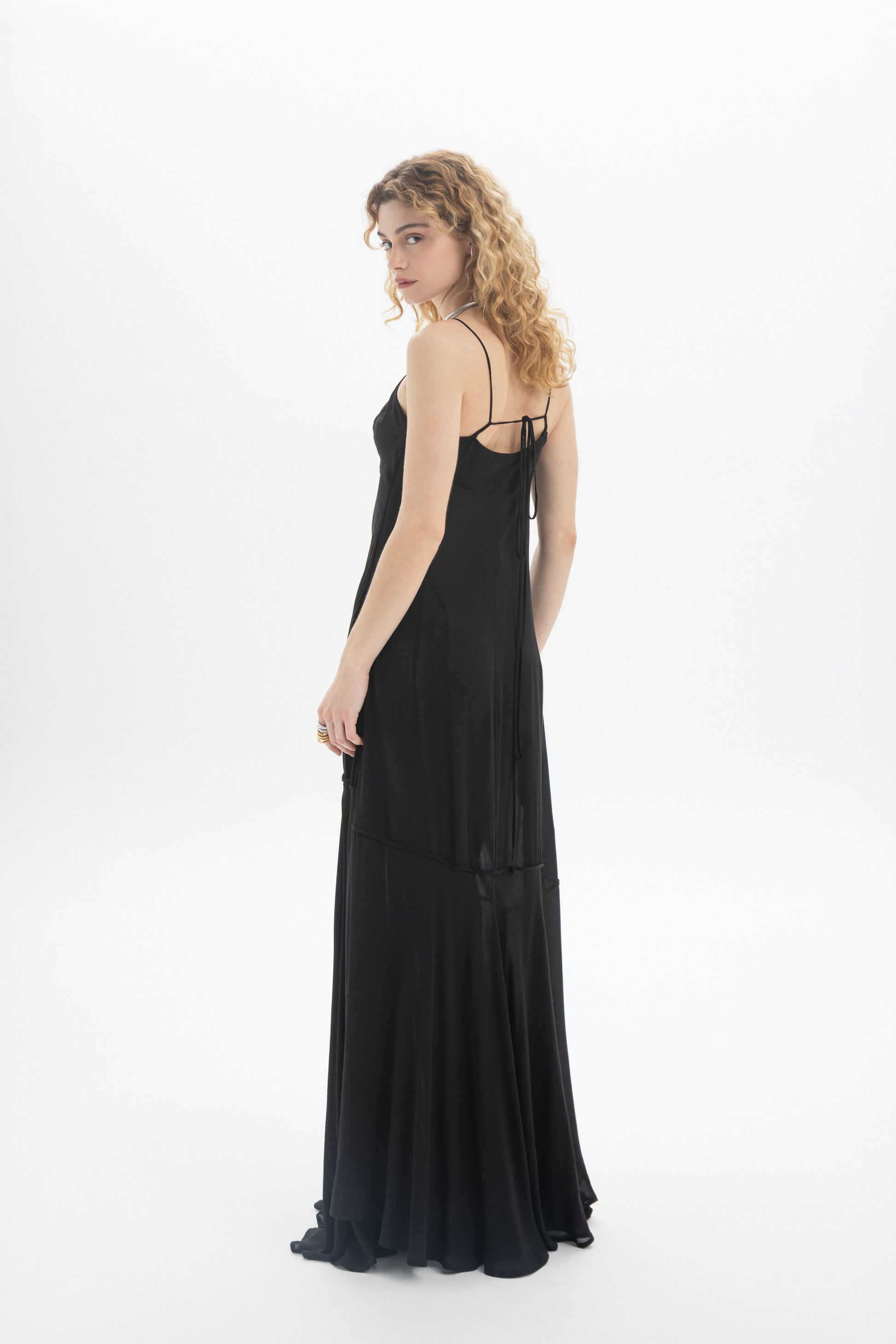 Model wearing a V-Neck Maxi Dress with thin straps and a flowing tiered hem, showcasing a relaxed fit.